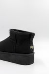 Black ankle boot with visible brand logo on a white background
