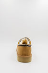 A single men's synthetic suede clog with a decorative black, white, and gold zigzag trim around the collar shown from the back on a light gray background.