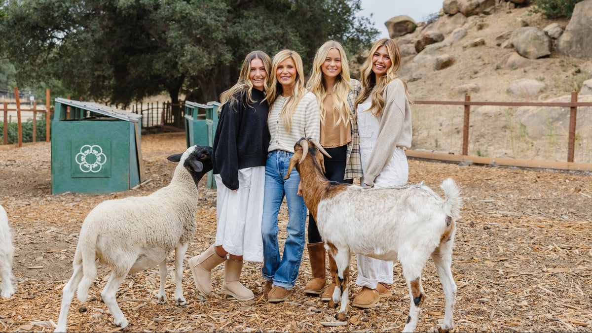 Group of women at Kindred Spirits Animal Sanctuary wearing cruelty-free PAWJ footwear with sheep and goats